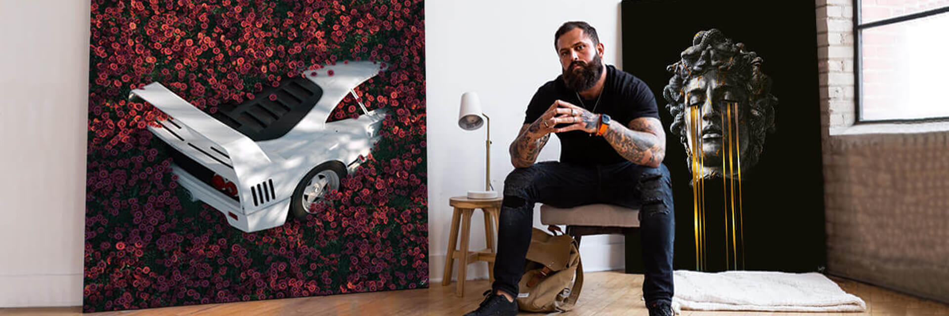 man sitting in front of a painting of a statue with yellow tears streaming from its eyes.