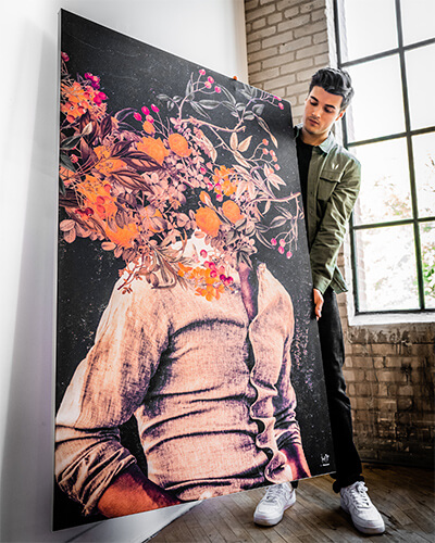 An artist inspecting a floral head art piece, as an example of a large wall art trend