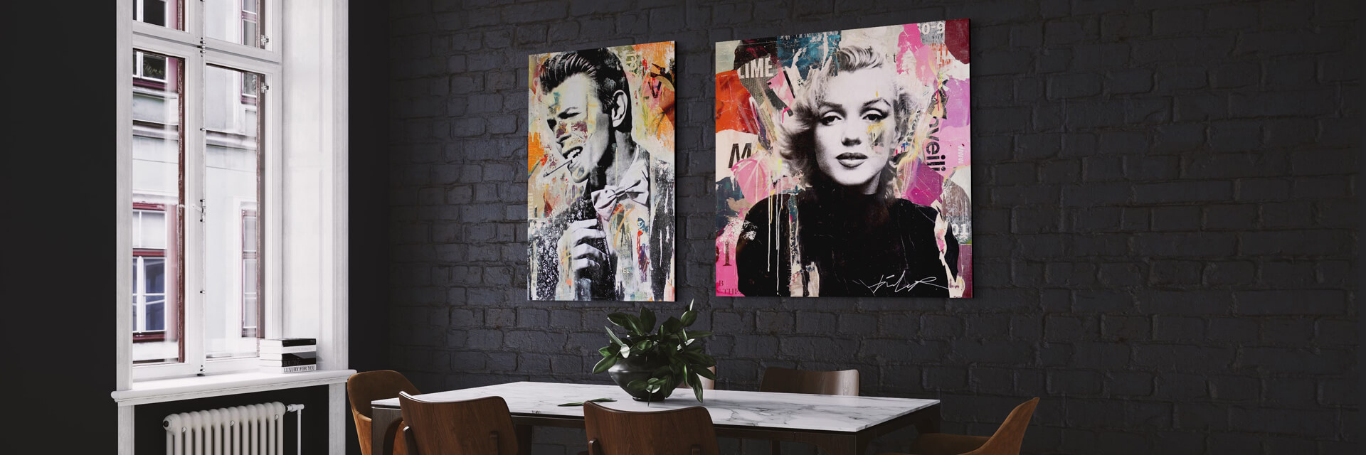 Two pop art photos hang side by side on black painted brick wall in city apartment dining room. Each large pop artwork shows a celebrity in black and white surrounded by a colorful collage.