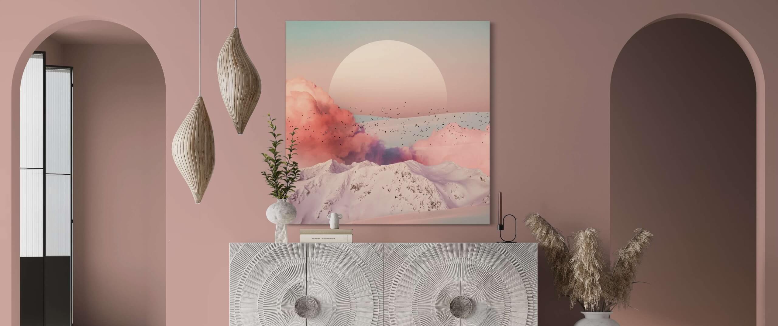 Oversized pink surreal artwork showing massive moon with pink smoke hangs in feminine decorated Airbnb living room