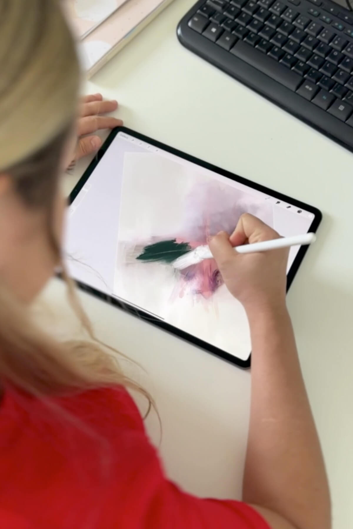 Abstract artist Karine Tonial Grimm as she draws on her iPad in dark blue over light purple to create one of her abstract masterpieces. The artist's skilled movements can be seen as she works on the digital canvas, bringing her vision to life.