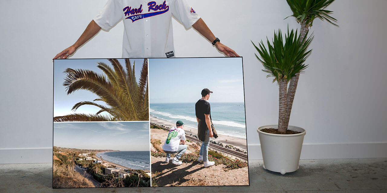 Man hold custom art print of beach photos from his phone in the living room of his apartment.