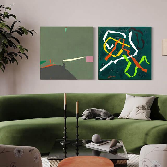 Two pieces of green abstract art hang side by side above couch in living room.