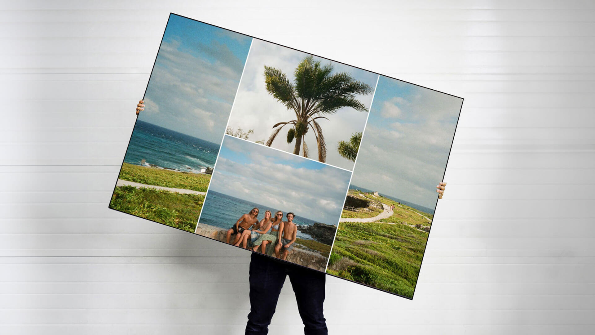 Large custom collage art print featuring 4 beach pictures from vacation is held by person.