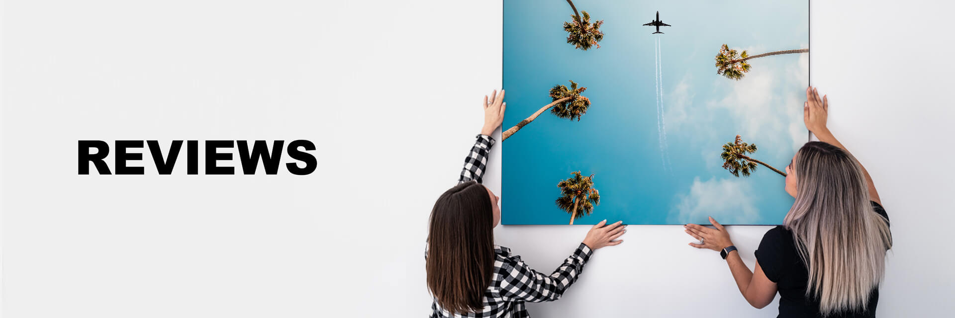 two women are holding up a print with the words reviews.