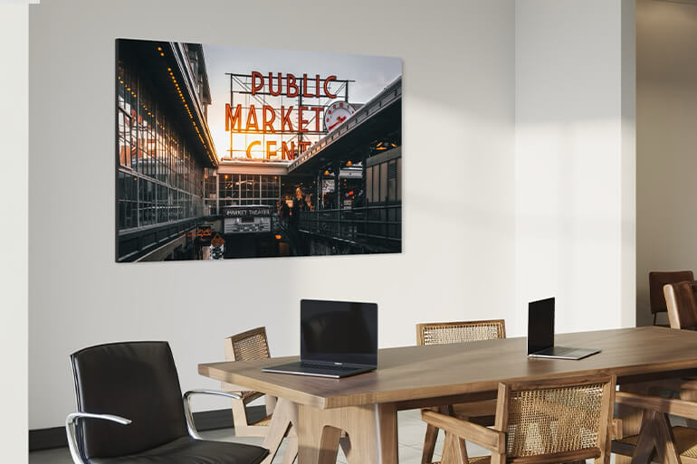 Modern office with a large wall art print of the Public Market Center sign at sunset, adding an urban and sophisticated touch to the meeting room.