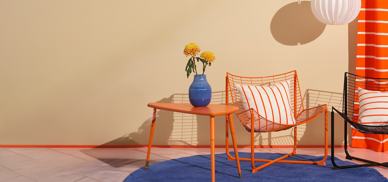 Bold wire accent chairs in orange and black with striped cushions and playful color-blocked decor.