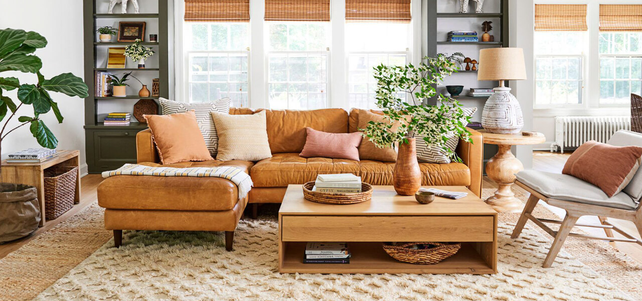 Warm and cozy living room with a leather sectional, textured rug, wood coffee table, and layered décor accents