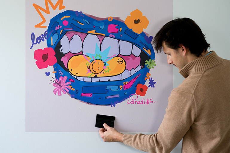 College student hanging blue graffiti pop art lips print on dorm wall