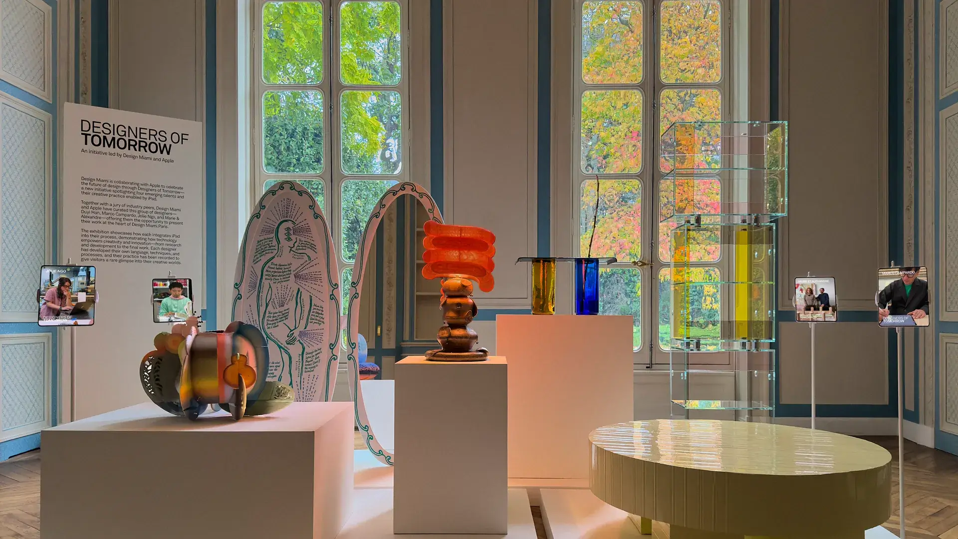 Modern design exhibition with unique sculptural furniture, glass shelving, and colorful art at Design Miami’s Designers of Tomorrow showcase.