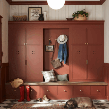 Mudroom painted in Warm Mahogany, a warm terracotta red, featuring paneled walls, brass accents, and rustic details styled with cozy textures and decor.
