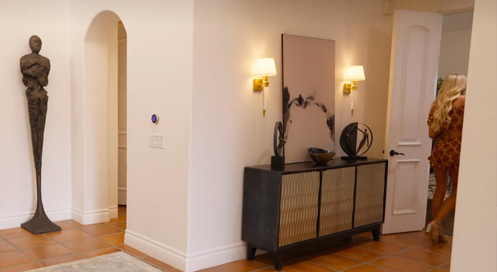 Minimal black and white artwork leaning on a cabinet in a modern living room.