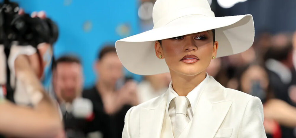 Zendaya wearing a white tailored Louis Vuitton suit and oversized hat at the 2025 Met Gala