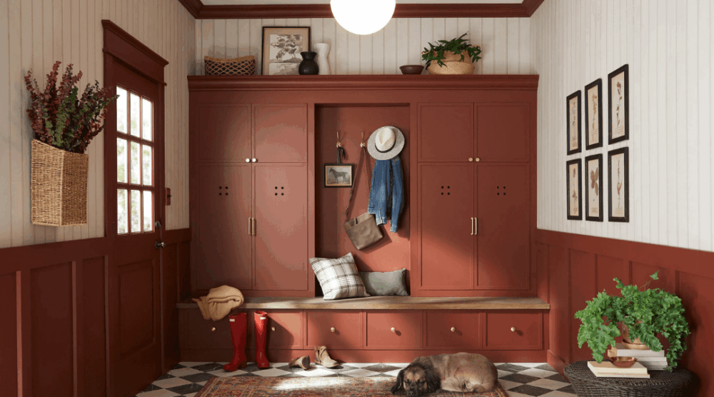 Mudroom painted in Warm Mahogany, a warm terracotta red, featuring paneled walls, brass accents, and rustic details styled with cozy textures and decor.