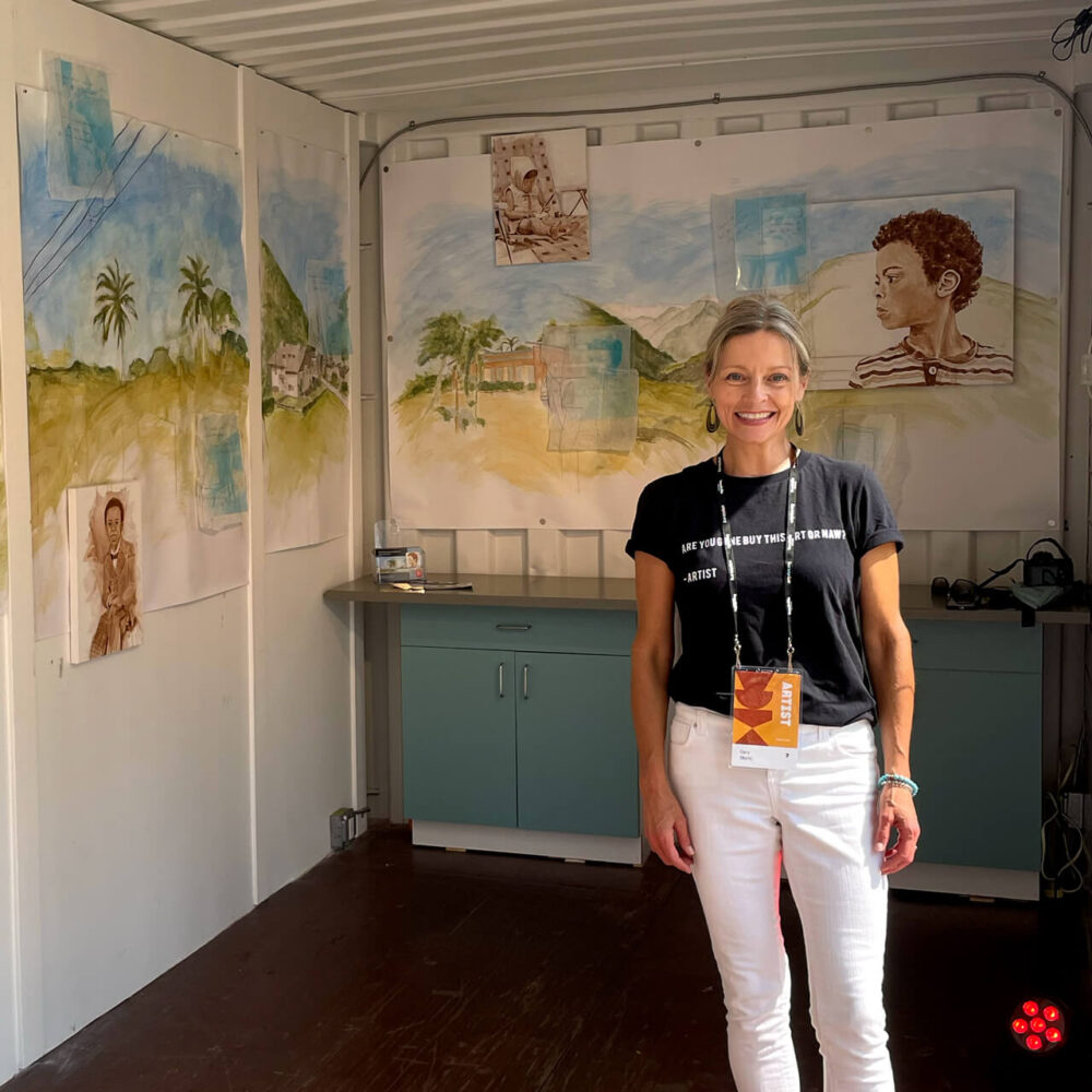 Painter Cary Okoro Stands In Front of Her Blue, Green, and Brown Painted ArtPrize 2022 Exhibit "We Reach Across The Same Blue Sky" on Display in the Muse GR Art Pod.