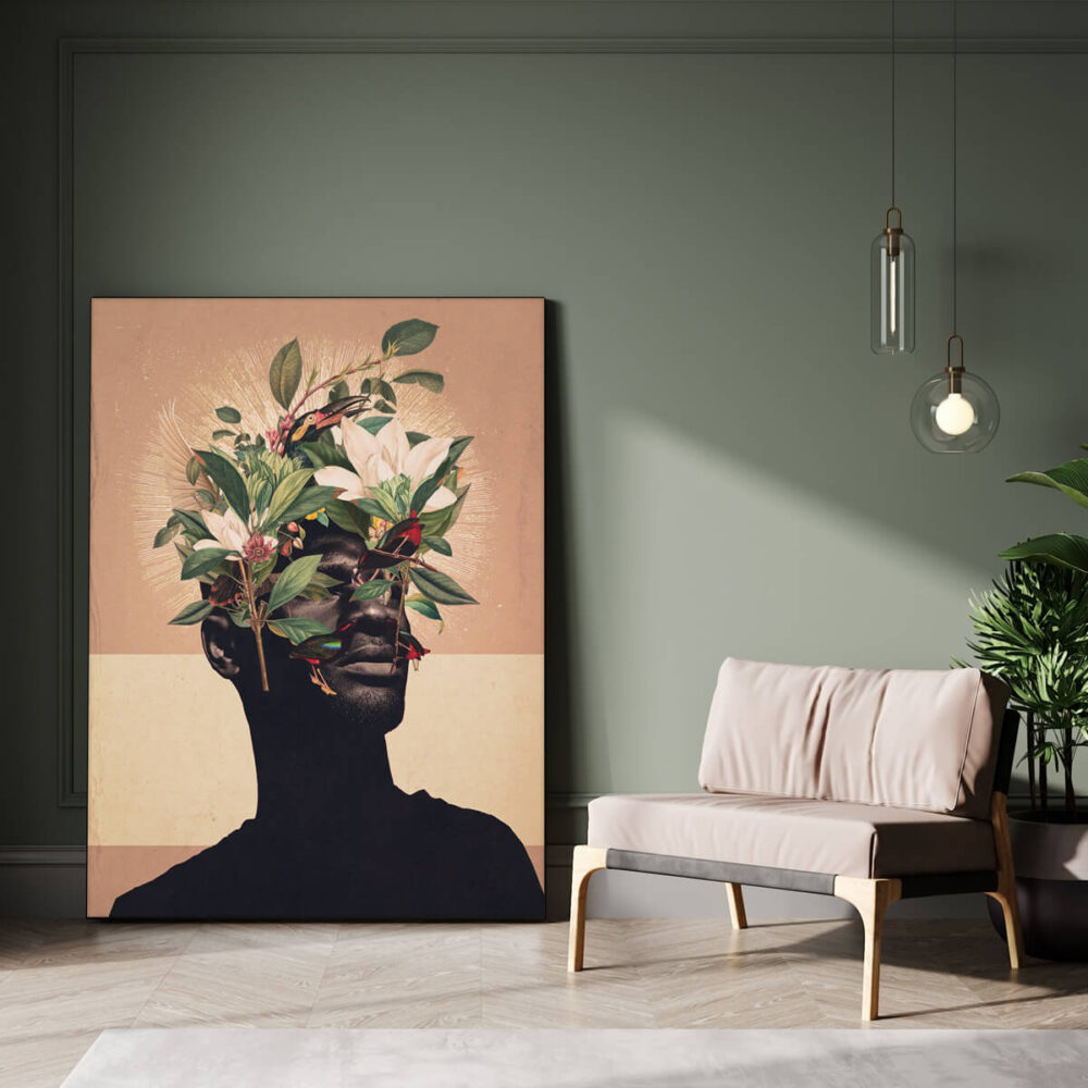 Large flower head wall art of black man's profile covered with tropical birds and flowers on a light orange background leans up against green wall in living room
