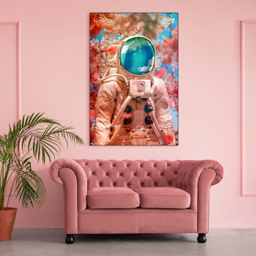 Oversized pink astronaut art hanging on light pink wall above pink couch