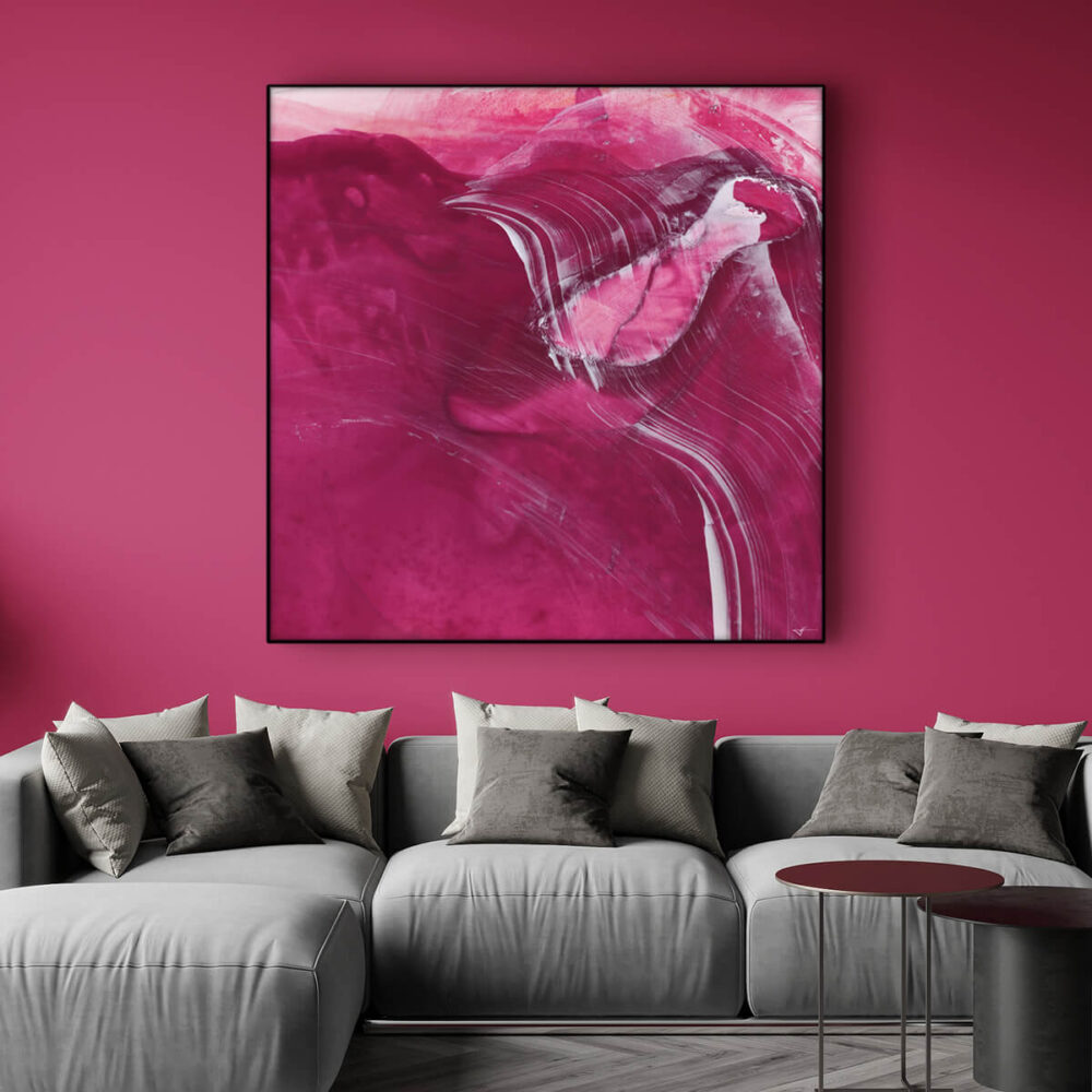 Living room with powerful accent wall in Viva Magenta features abstract magenta painting hanging above light grey couch.