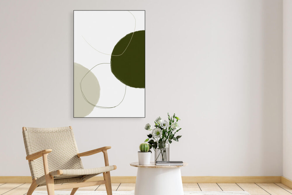 Minimalist tan and sage green wall art hangs on neutral wall in living room above sitting area.