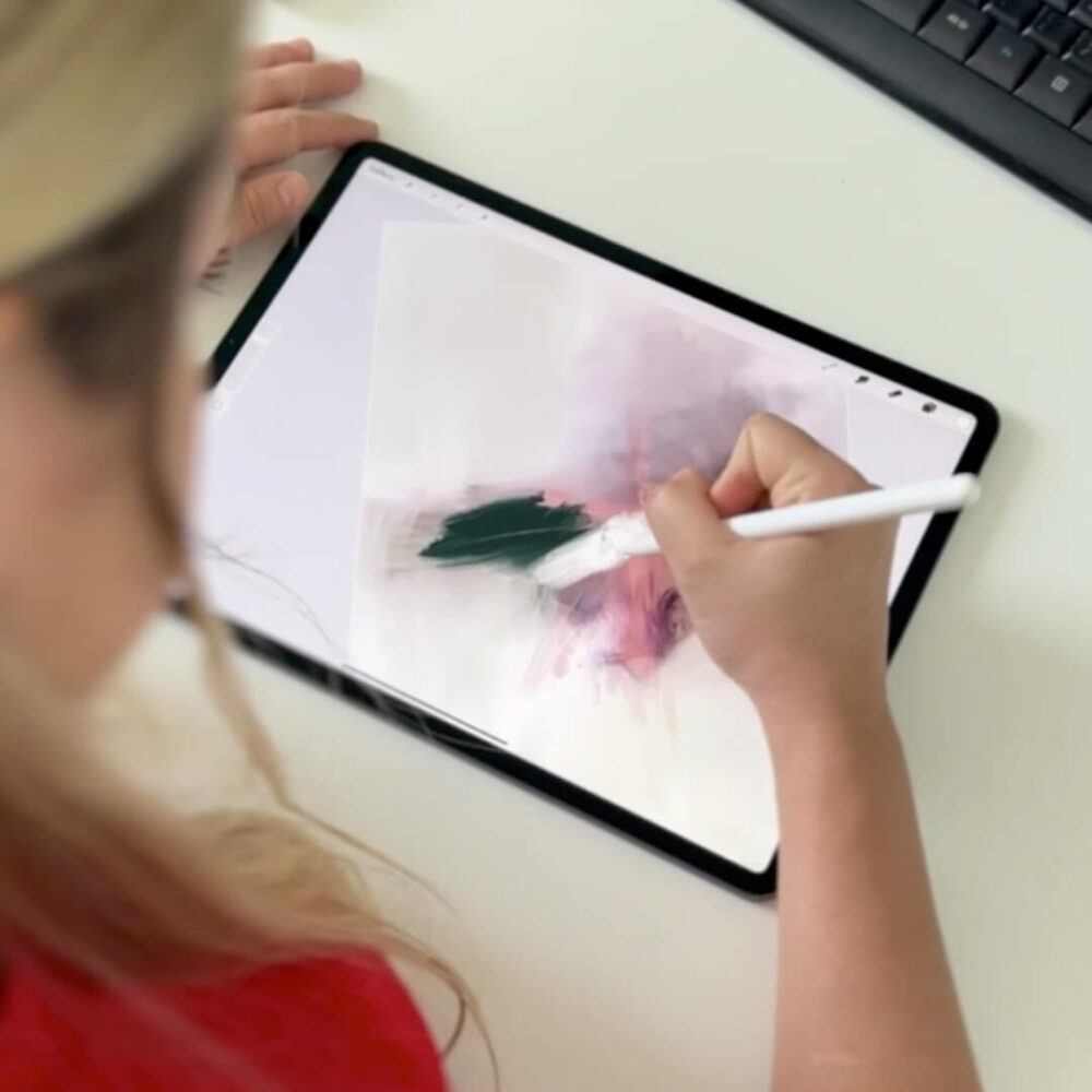 Abstract artist Karine Tonial Grimm as she draws on her iPad in dark blue over light purple to create one of her abstract masterpieces. The artist's skilled movements can be seen as she works on the digital canvas, bringing her vision to life.