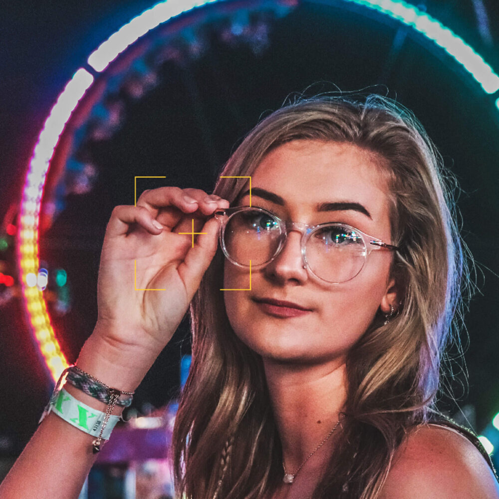 Phone screen showing photo of girl wearing glassed with a futuristic background.