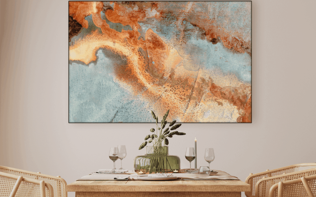 Scene of a dining area, all neutral and sort of warm colors with a beautiful abstract piece of artwork on the wall, tying the room together.