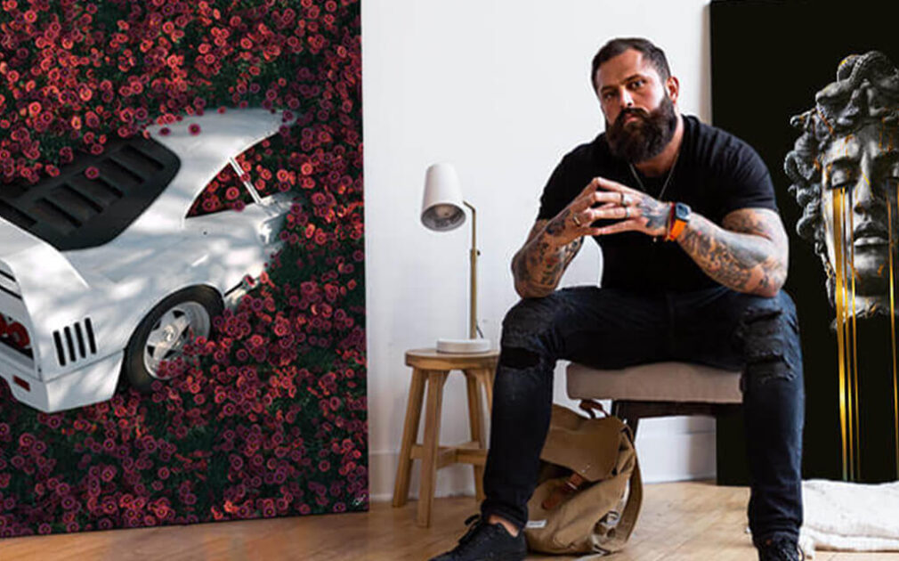 man sitting in front of a painting of a statue with yellow tears streaming from its eyes.