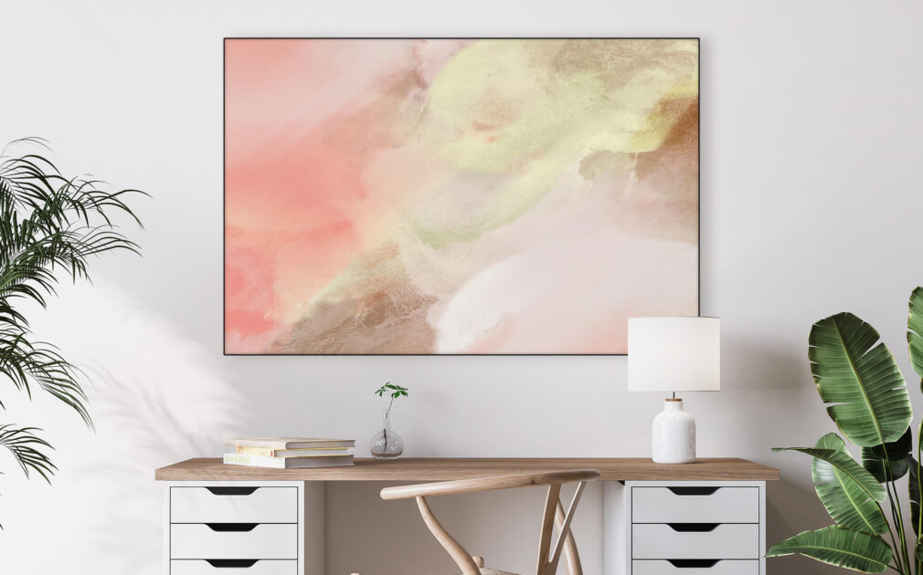 Large horizontal abstract blush pink and neutral painting hangs on white wall in home office above a desk.