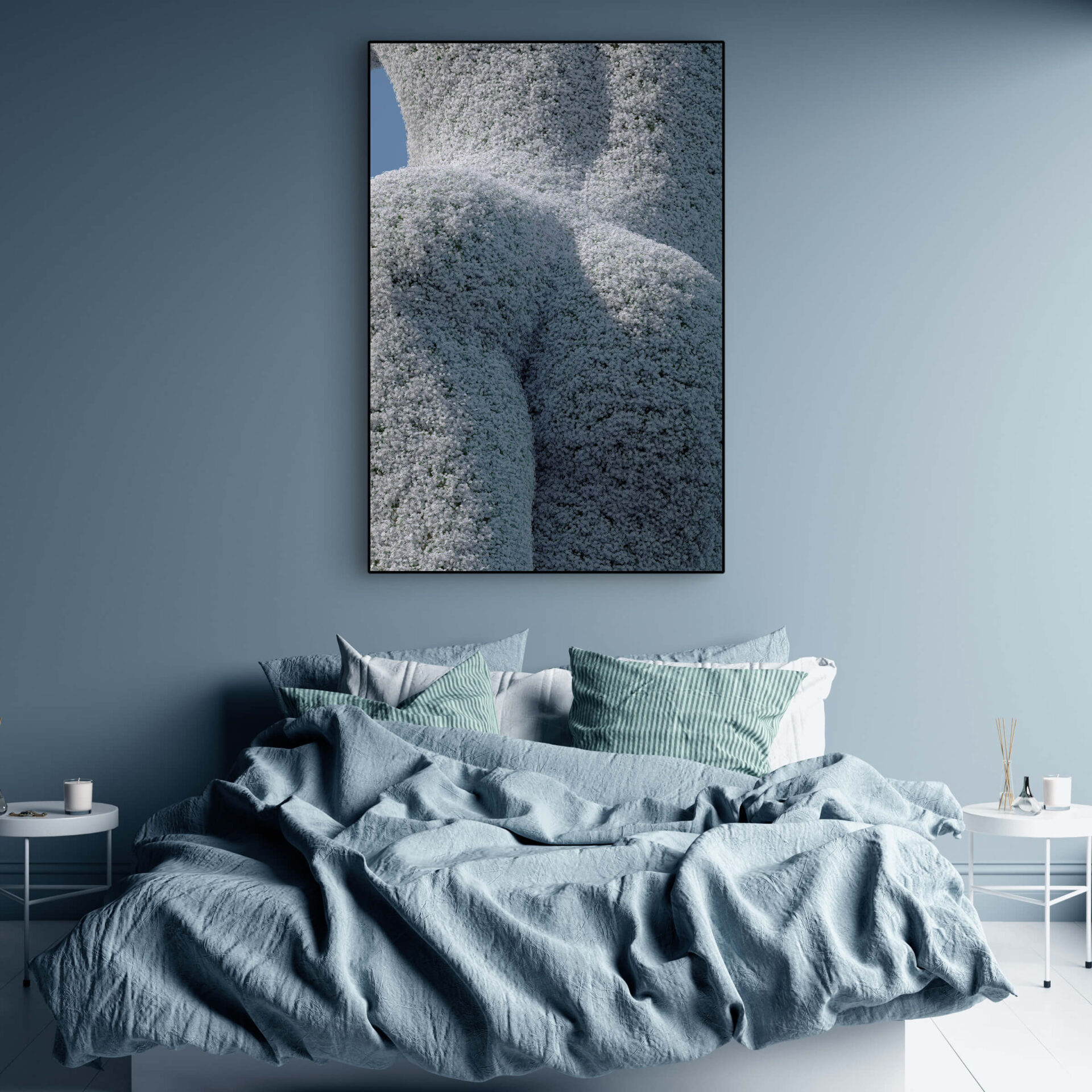 Oversized white flower wall art of hedge trimmed like woman's figure hangs above bed in blue bedroom.