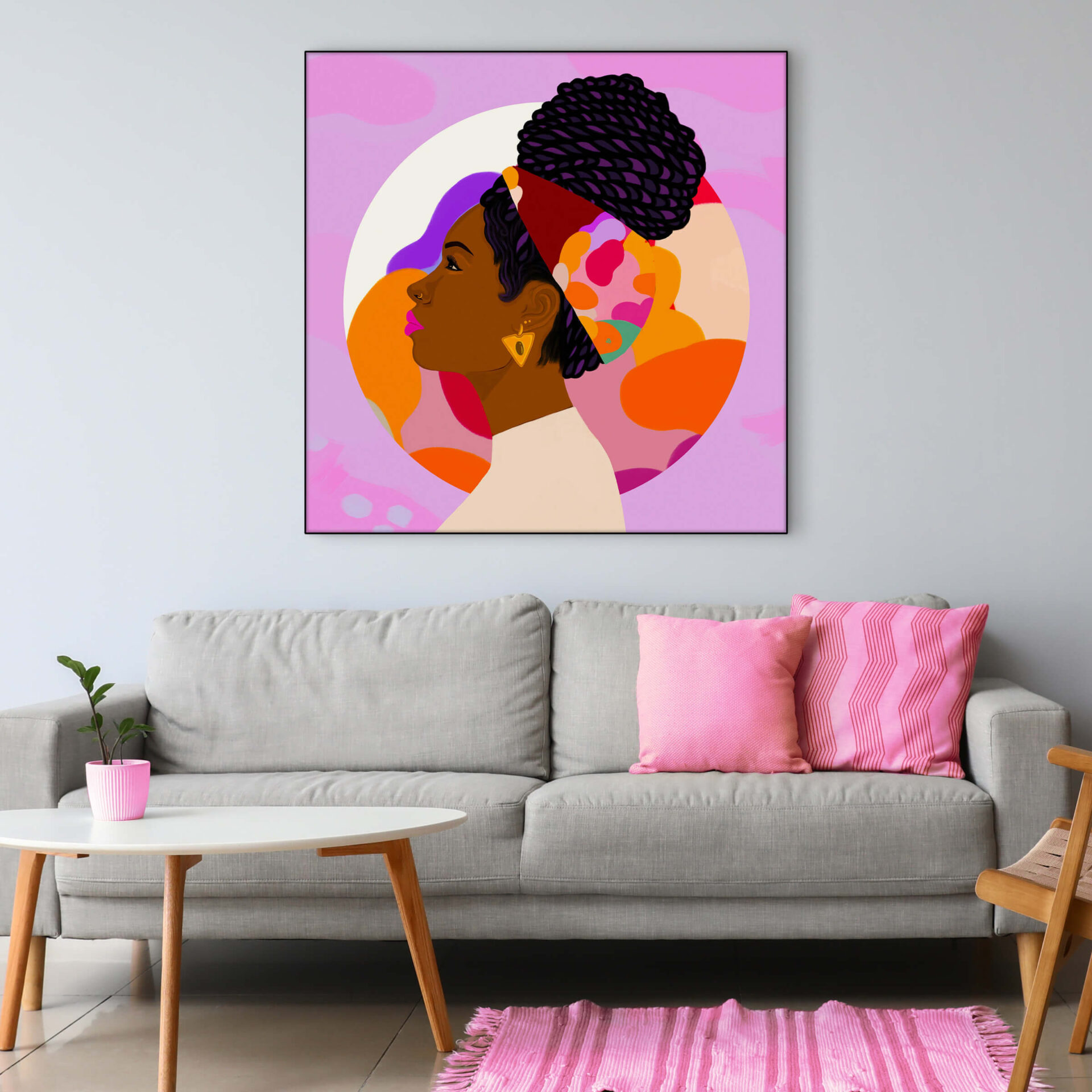 Pink wall art featuring Black Queen profile hangs on neutral wall in living room.