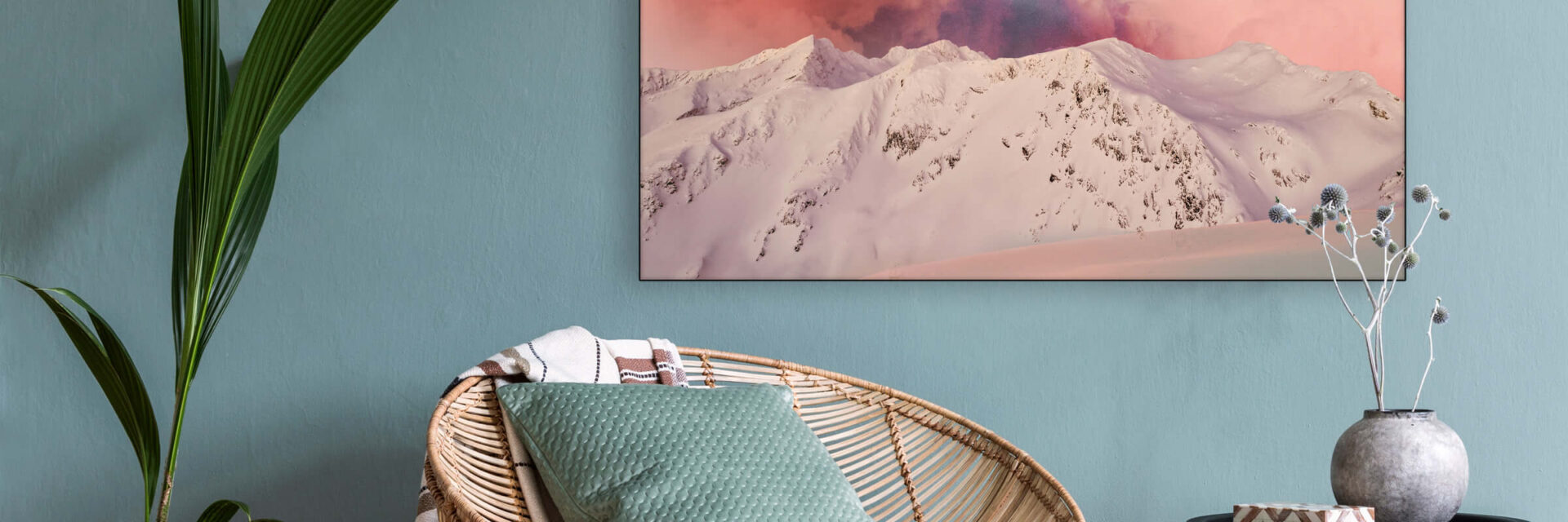 Massive pink boho wall art of surreal sunset hangs on blue wall in living room