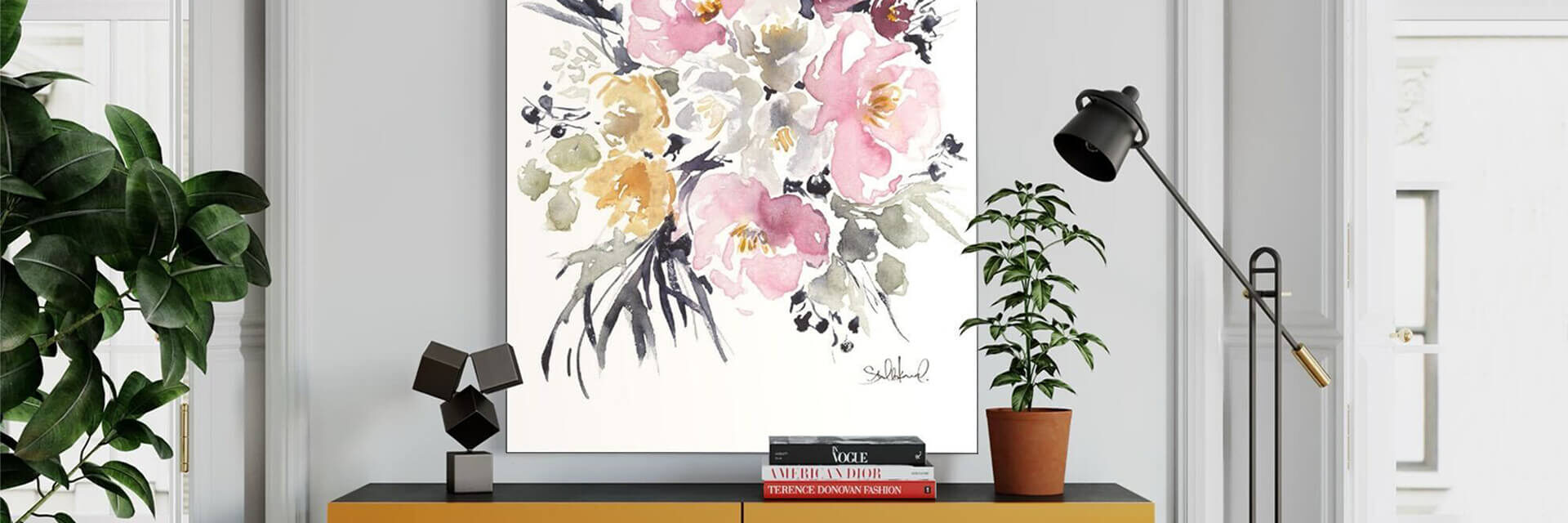 Large abstract watercolor painting of light flowers hangs in neutral home office above desk.