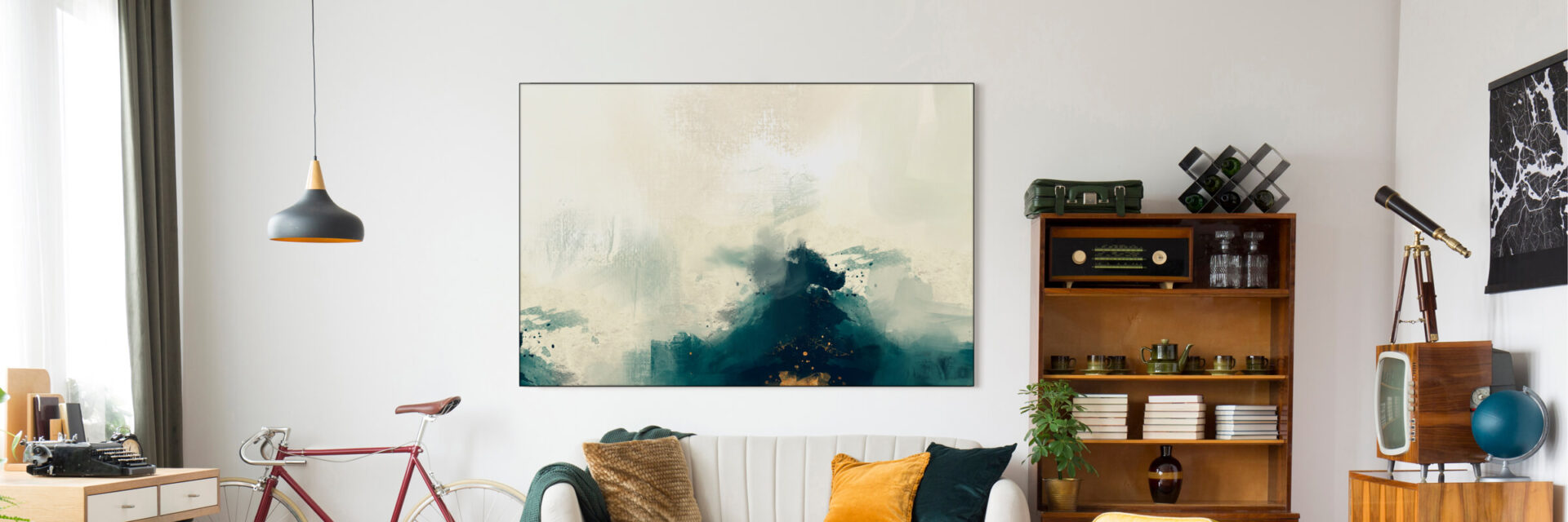 Artwork hanging on modern living room wall above couch features a color palette of blue, white, with accents of gold.