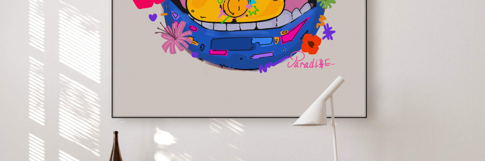 a desk with a piece of pop art hanging on the wall above it, featuring a colorful cartoon mouth with a yellow pill in it.