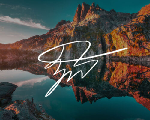Autumn Landscape photo of mountain at sunset reflecting on lake with Zach Doehler signature in white