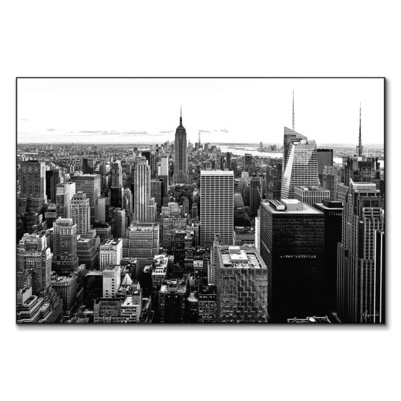 Black and white aerial view of New York City with the Empire State Building prominently in the center.