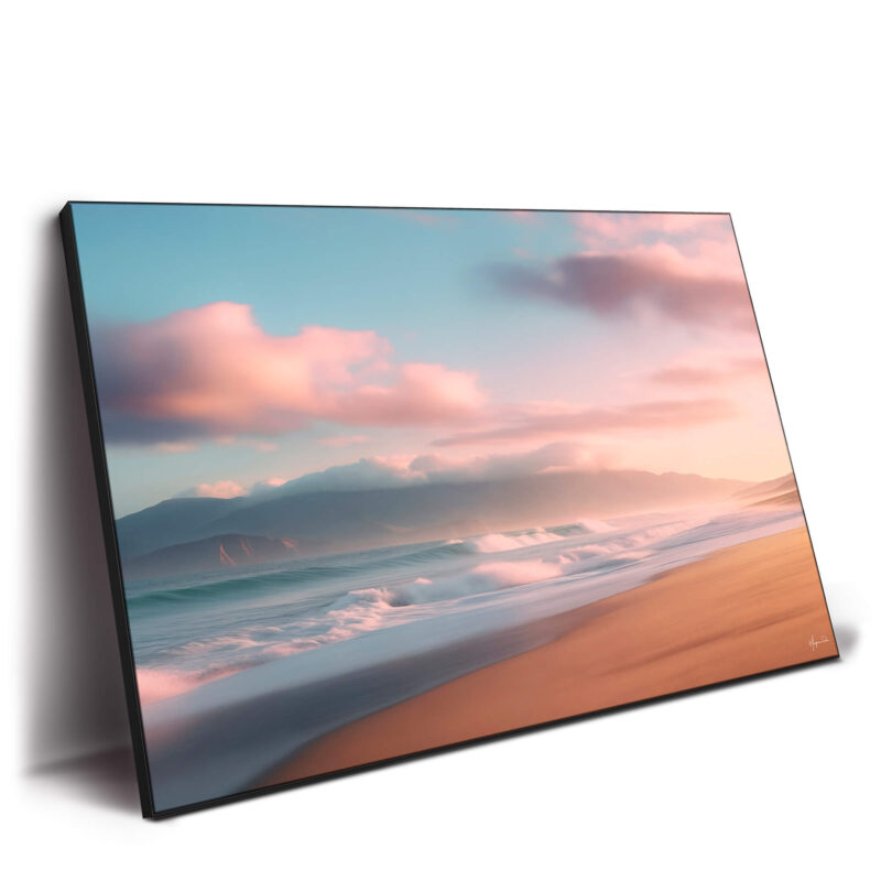 Beach at sunrise with gentle waves, pink clouds, and mist-covered mountains.