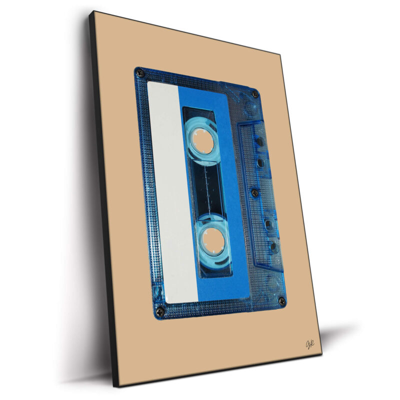 Translucent blue audio cassette tape with a white and blue label against a warm tan background.