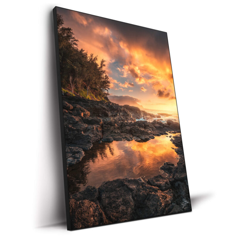 Sunset over the rugged coastline of Kauai, Hawaii, with fiery sky colors.