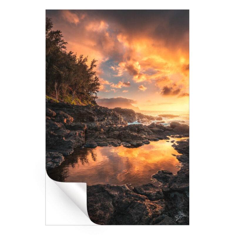 Sunset over the coastline of Kauai, Hawaii, with fiery sky colors.