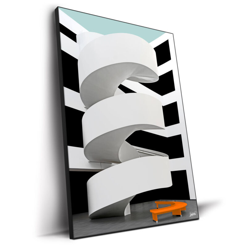 White architectural staircase with black and white background and an orange bench.