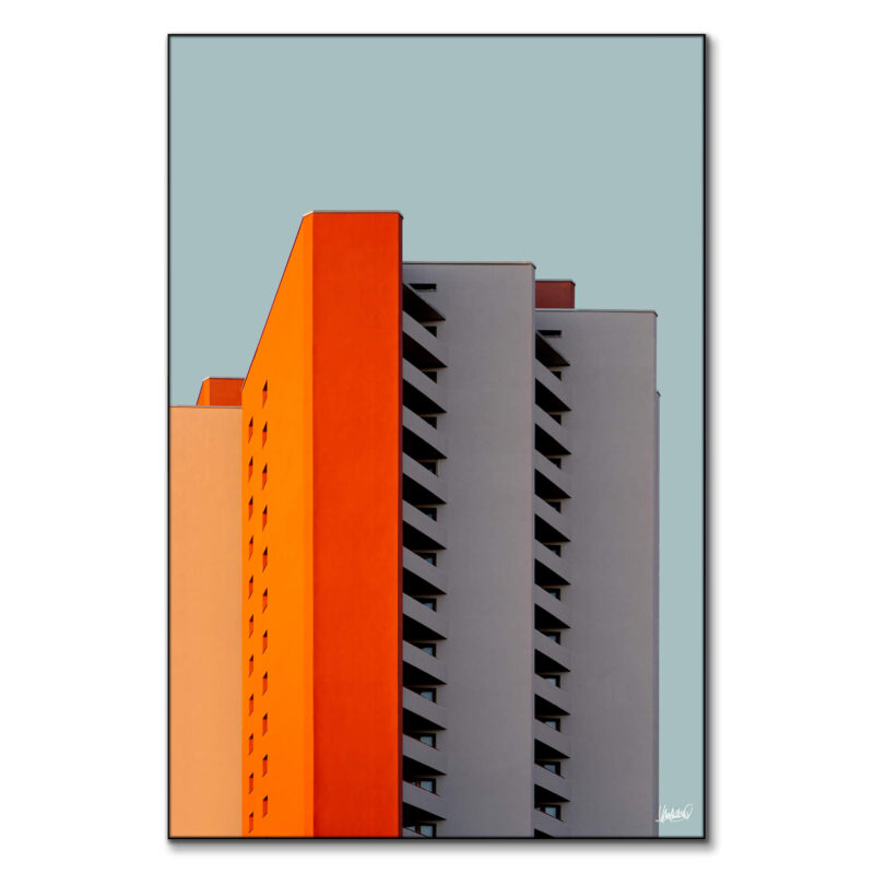 Surreal building with orange, gray, and peach facade, showcasing modern design.