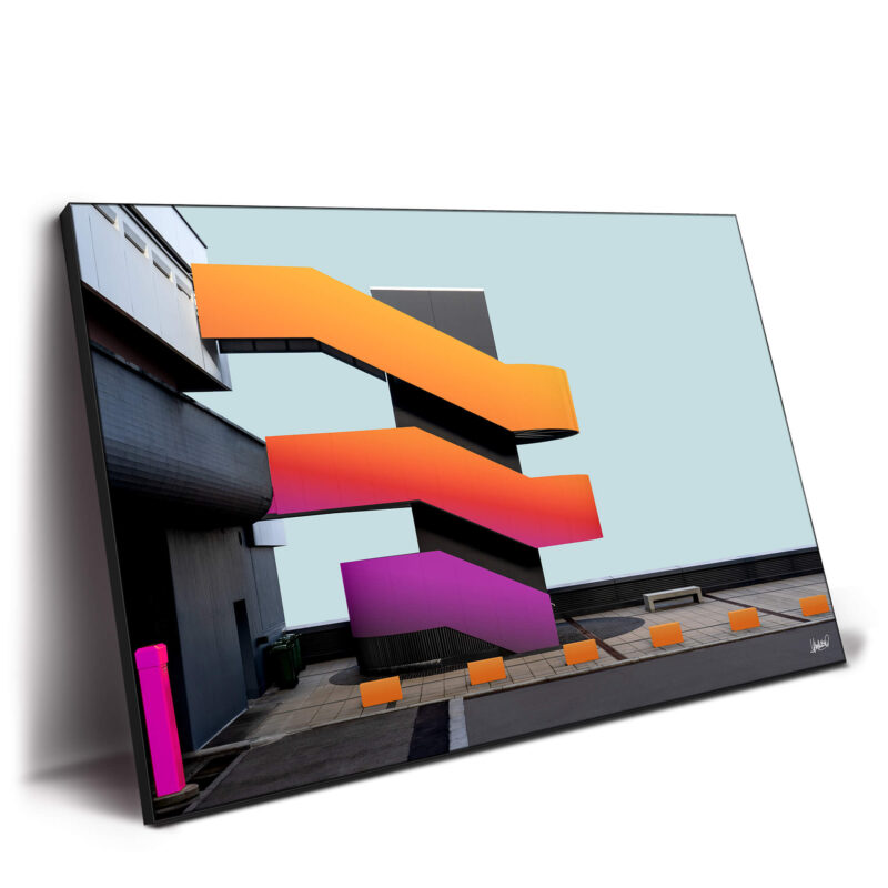 Staircase with vibrant orange and pink hues, set against a dark building background, featuring dynamic design.