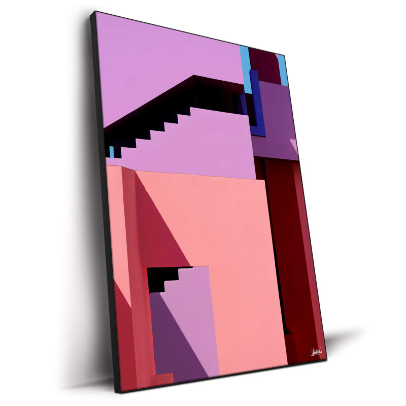Vibrant geometric architecture with pink, purple, and red blocks and shadowed stairs.