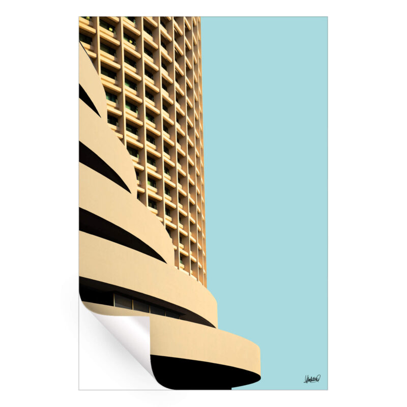 Curved high-rise building with repetitive windows against a pale blue sky.