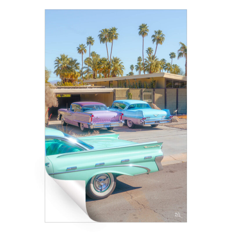 Pastel vintage cars parked in front of a mid-century modern house with palm trees in Palm Springs.