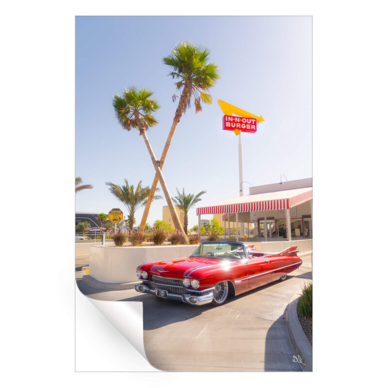 Red convertible parked in front of an In-N-Out Burger with palm trees and a clear sky.