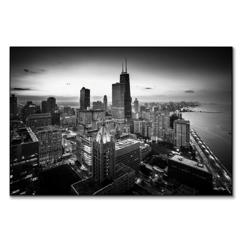 Aerial view of Chicago's downtown loop in black and white, showcasing the skyline and iconic buildings against a twilight sky.