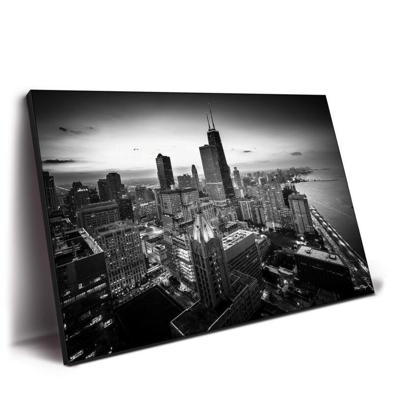 Aerial view of Chicago's downtown loop in black and white, showcasing the skyline and iconic buildings against a twilight sky.