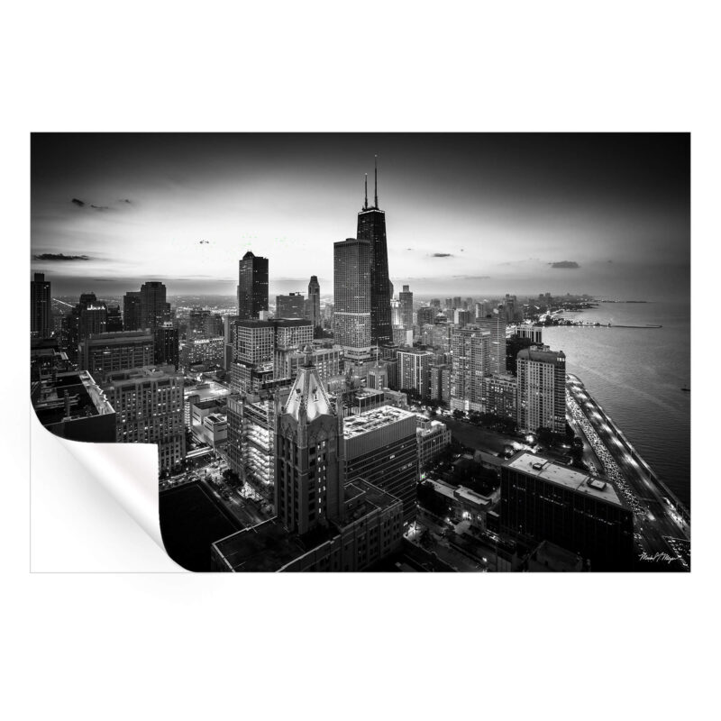 Aerial view of Chicago's downtown loop in black and white, showcasing the skyline and iconic buildings against a twilight sky.